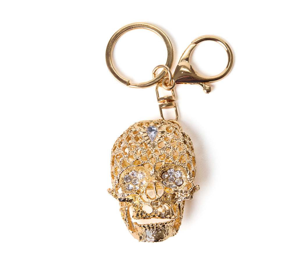 Gold skull bag charm and keychain with gemstones on a white background